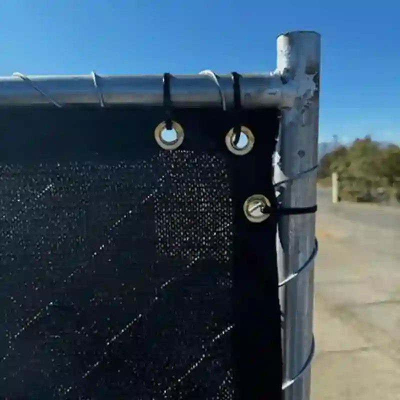 close-up of a Chain Link Fence with privacy fabric attached using zip ties and screws.